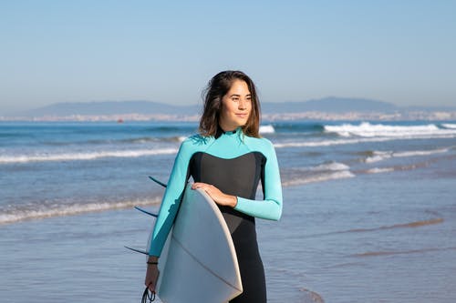 黑色背心抱着白色冲浪板的女人 · 免费素材图片