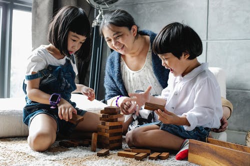 祖母和亚洲孙子一起玩塔游戏 · 免费素材图片