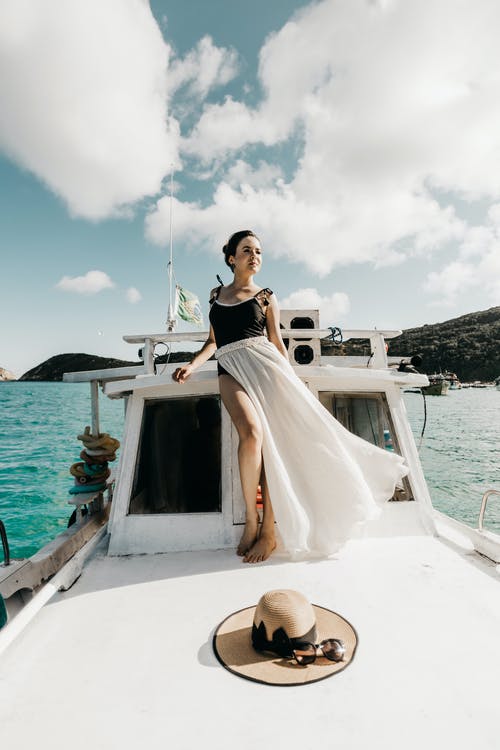 泳装和白色裙子站在甲板上的女人 · 免费素材图片