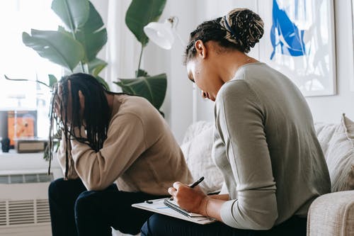 沮丧的黑人与女性心理治疗师分享问题 · 免费素材图片