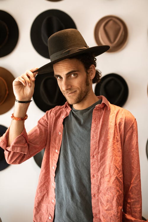 一个戴着黑色软呢帽的男人看着相机 · 免费素材图片