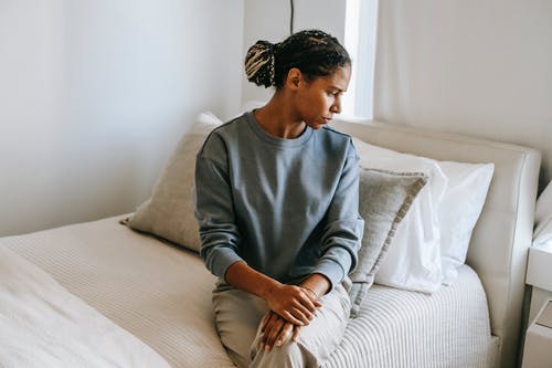 黑人妇女在家坐在床上 · 免费素材图片