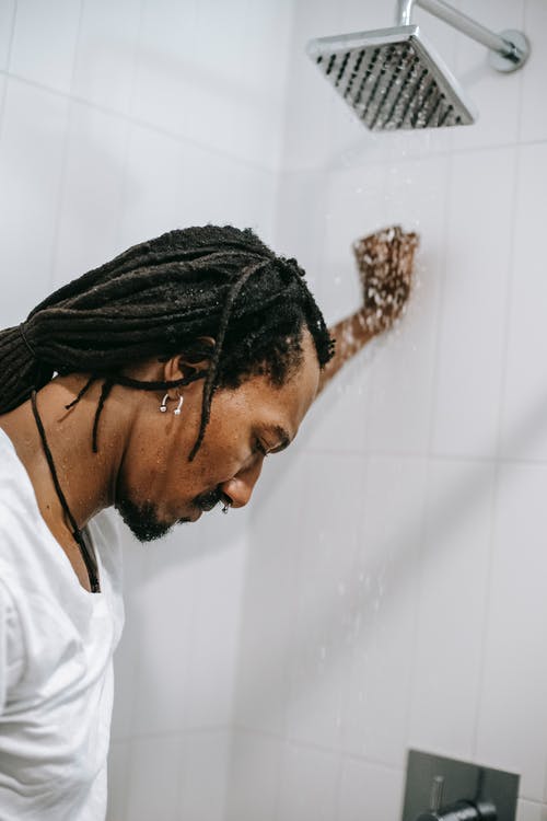 沮丧的黑人在淋浴间在水之下 · 免费素材图片