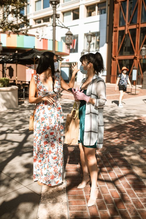 2名穿着白色和蓝色碎花连衣裙的女人站在棕色的水泥地板上 · 免费素材图片