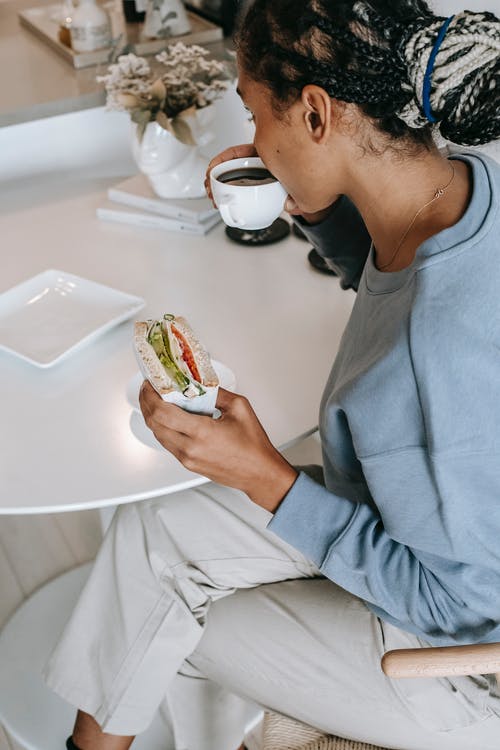 黑人妇女在厨房里吃早餐 · 免费素材图片