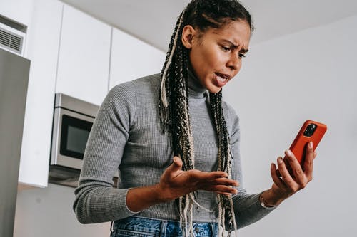 恼火的黑人妇女在智能手机上在家有视频聊天 · 免费素材图片