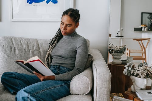 在家里集中年轻族裔女士看书沙发 · 免费素材图片