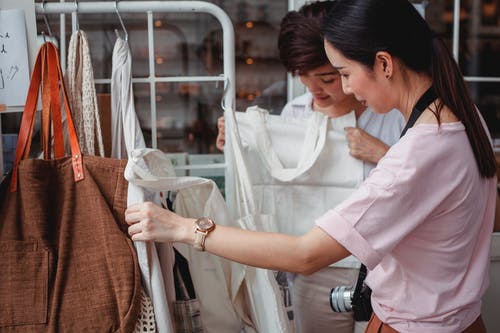 亚洲时尚年轻女性在时尚精品店选择棉布袋 · 免费素材图片