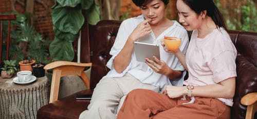 迷人的亚洲妇女与平板电脑和咖啡 · 免费素材图片