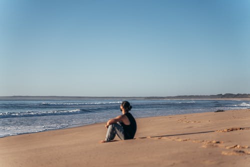 在平静的沙滩上休息的面目全非的人 · 免费素材图片