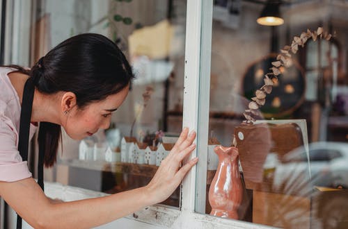 亚裔妇女感人的商店陈列室与装饰项目 · 免费素材图片