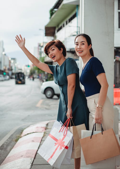 亚裔女子和纸袋赶上出租车 · 免费素材图片