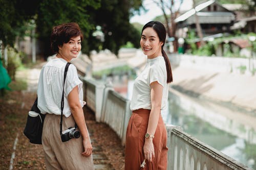 幸福的亚洲女人，在运河附近的城市路堤上 · 免费素材图片