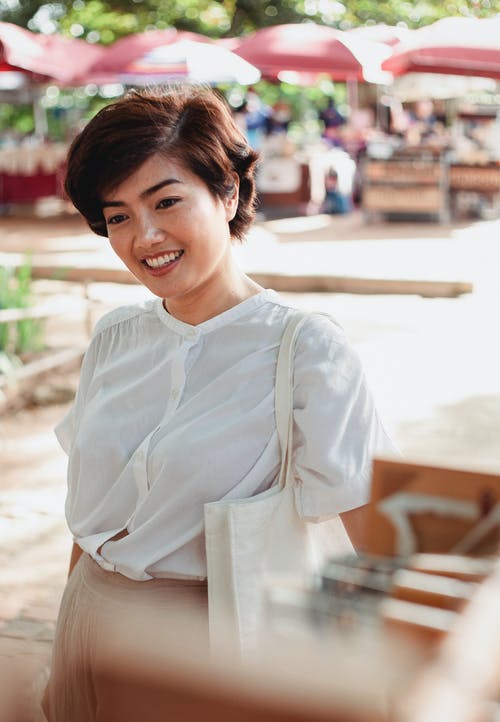 站立在晴朗的市场上的可爱的亚裔妇女 · 免费素材图片