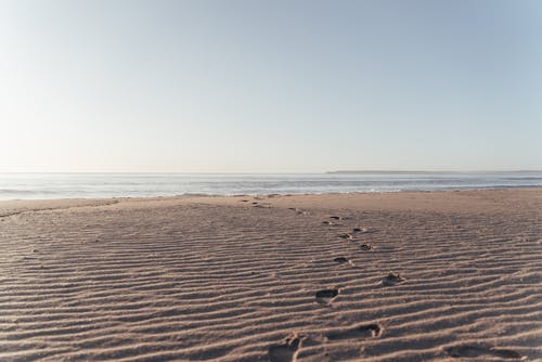 沙滩与人类足迹在晴朗的一天 · 免费素材图片