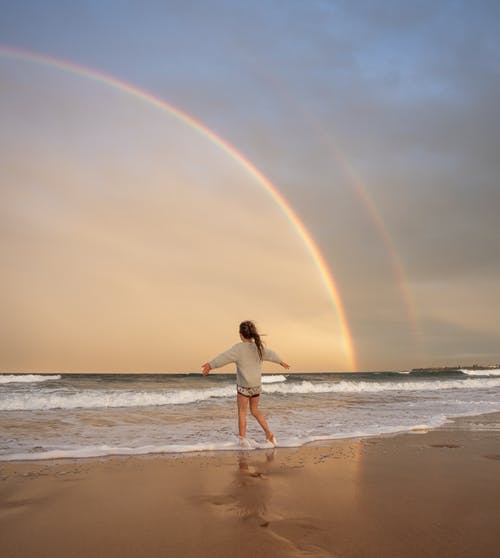 海滩的匿名妇女与彩虹 · 免费素材图片
