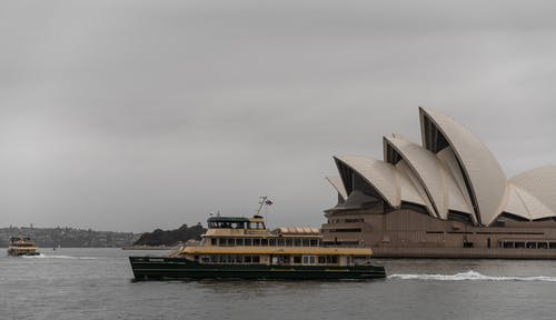 游轮在暮色中沿着雄伟的悉尼歌剧院漂浮 · 免费素材图片