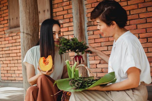 嗅到绿色的亚裔妇女离开坐在街道上 · 免费素材图片