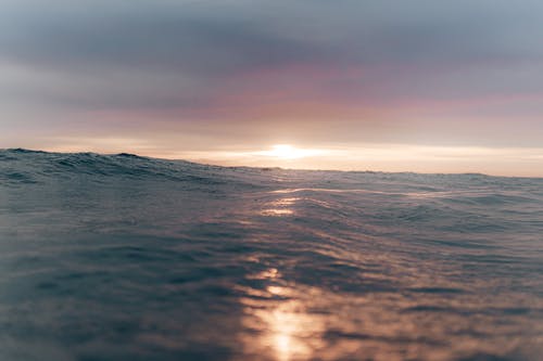 多云的夕阳的天空在波浪海 · 免费素材图片