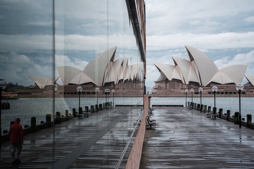 雄伟的悉尼歌剧院在邻居的玻璃墙中反射 · 免费素材图片
