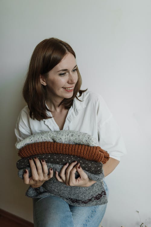 拿着棕色和黑色纺织的白色礼服衬衫的女人 · 免费素材图片