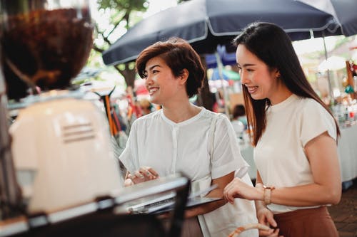 开朗的亚洲妇女在街头自助餐厅点饮料 · 免费素材图片