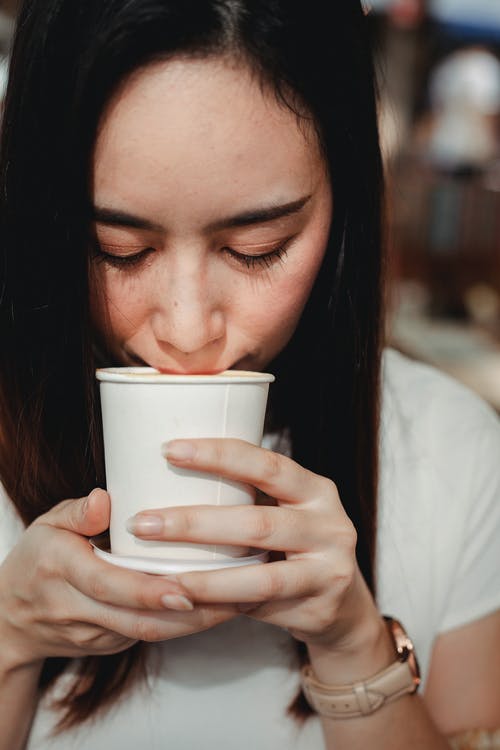 作物亚洲女人从纸杯喝热饮料 · 免费素材图片