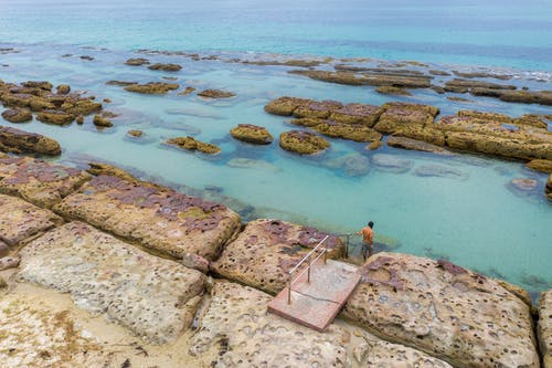岩石海岸与金属楼梯 · 免费素材图片