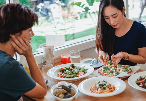 坐在餐桌旁的亚裔妇女用美味食物 · 免费素材图片