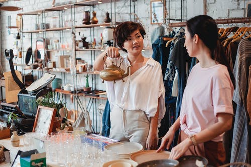 亚洲买家向女友在商店展示水壶 · 免费素材图片