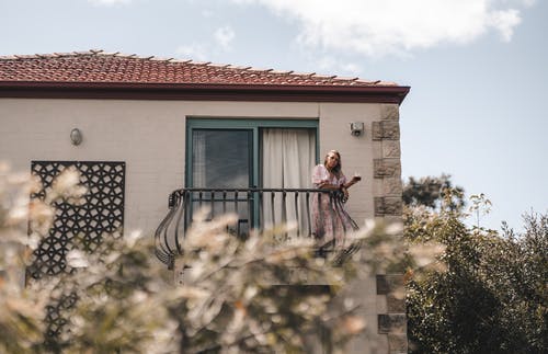 站在房子的阳台上的女人 · 免费素材图片