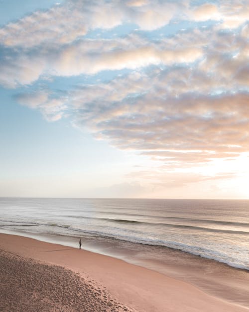 孤独的人站在沙滩上 · 免费素材图片