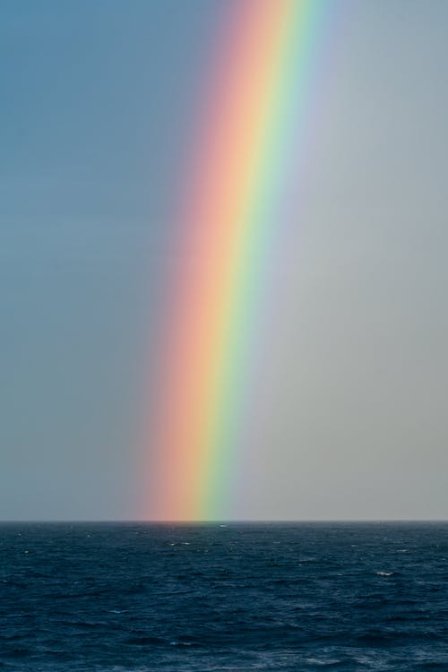 天空与彩虹在荡漾的蓝色海洋 · 免费素材图片