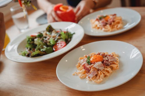 美味的意大利面和桌上的沙拉 · 免费素材图片