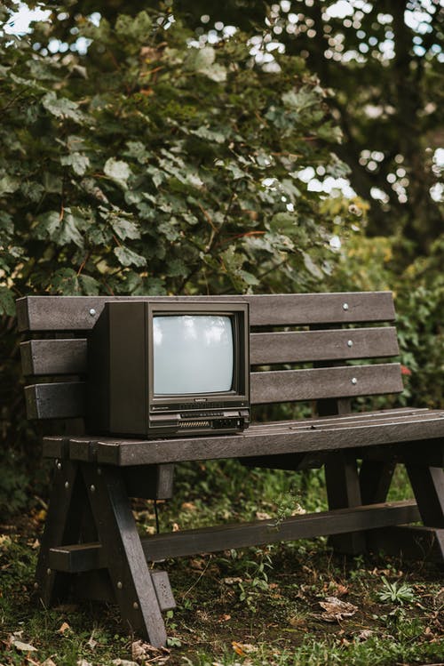黑色crt电视在棕色的木凳上 · 免费素材图片