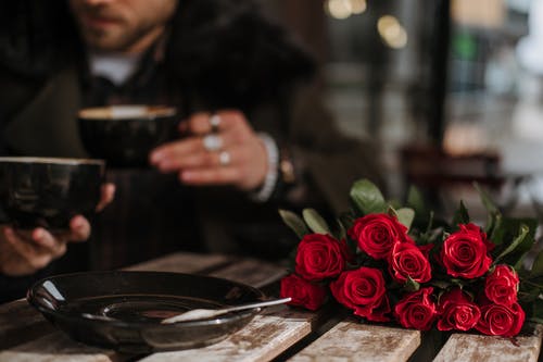 棕色的木桌上的红玫瑰花束 · 免费素材图片