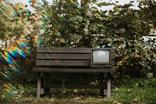 黑色crt电视在棕色的木凳上 · 免费素材图片