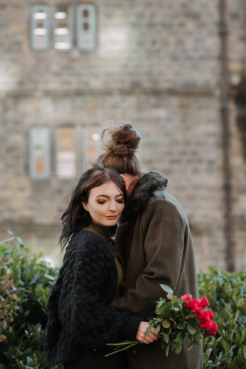 站在棕色外套的女人旁边的黑色外套的女人 · 免费素材图片