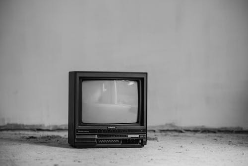 白墙上的黑色crt电视 · 免费素材图片