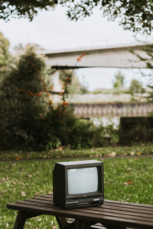 在绿色草地上的黑色crt电视 · 免费素材图片
