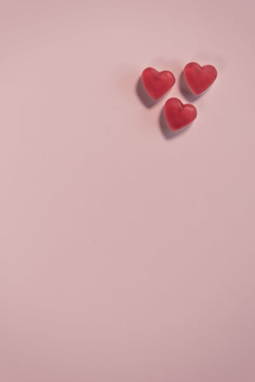 白色表面上的红色心形糖果 · 免费素材图片