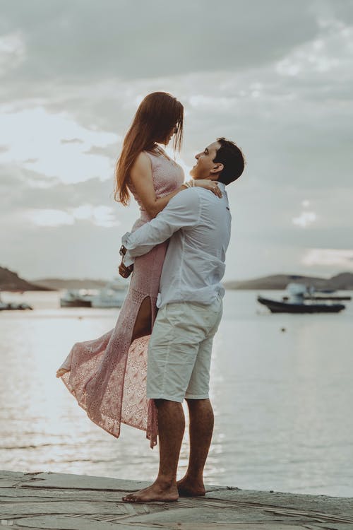 幸福的情侣站在海边的码头上 · 免费素材图片