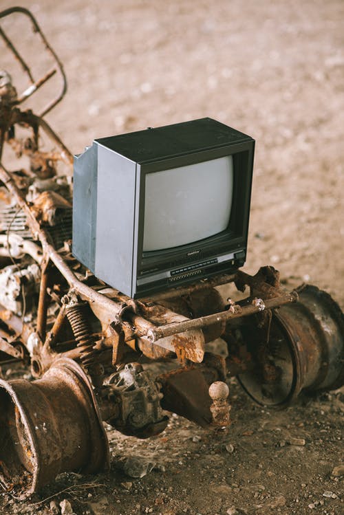棕色沙滩上的黑色crt电视 · 免费素材图片