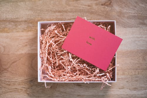 棕色的木桌上的红色贺卡 · 免费素材图片