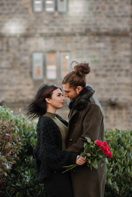 黑大衣的女人亲吻棕色大衣的女人 · 免费素材图片