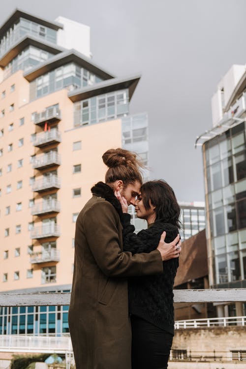 站在大楼附近的棕色外套的女人 · 免费素材图片