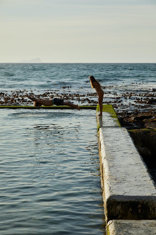 黑色比基尼站在棕色的木码头上的女人 · 免费素材图片