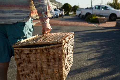 蓝色牛仔牛仔裤和棕色格子衬衫，拿着棕色编织的篮子里的人 · 免费素材图片
