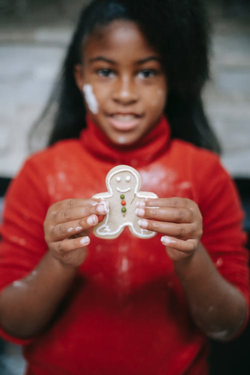可爱的黑人女孩，显示自制姜饼人 · 免费素材图片