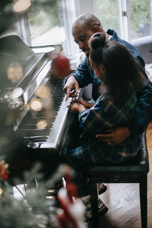 黑人小女孩和父亲一起弹钢琴 · 免费素材图片